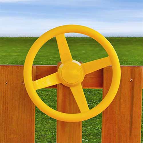 这是一张大猩猩玩具方向盘的特写，黄色，连接在木栅栏上，背景是草坪。