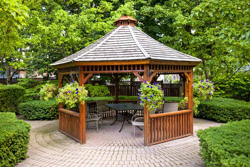 景观花园中的木制六角形凉亭与环环相扣的石头露台。