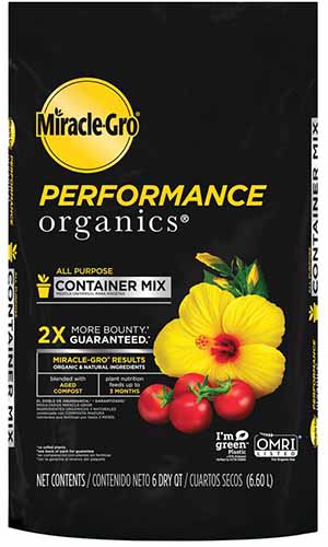 一个接近的黑色包装与黄色文本的Miracle-Gro性能有机盆栽土壤在白色背景。