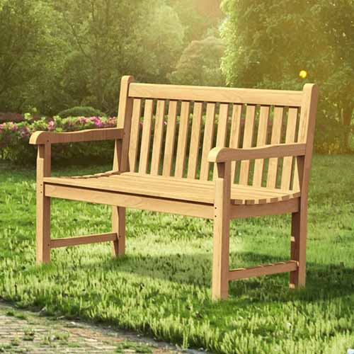 在傍晚的阳光下，露天柚木花园长椅的特写。