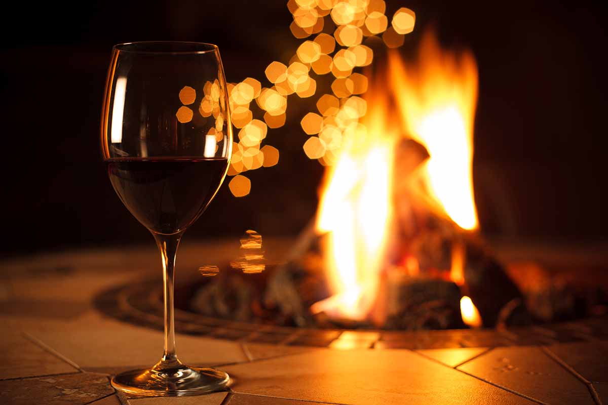一个近距离的水平图像的葡萄酒杯在装饰户外火坑前。