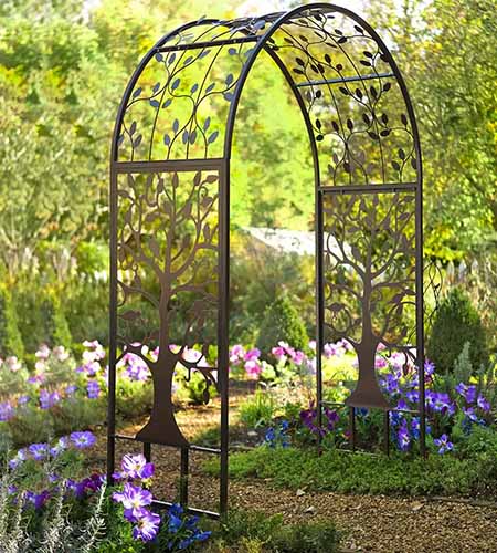 金属拱形花园凉亭的近距离与生命之树在花园里主题途径。
